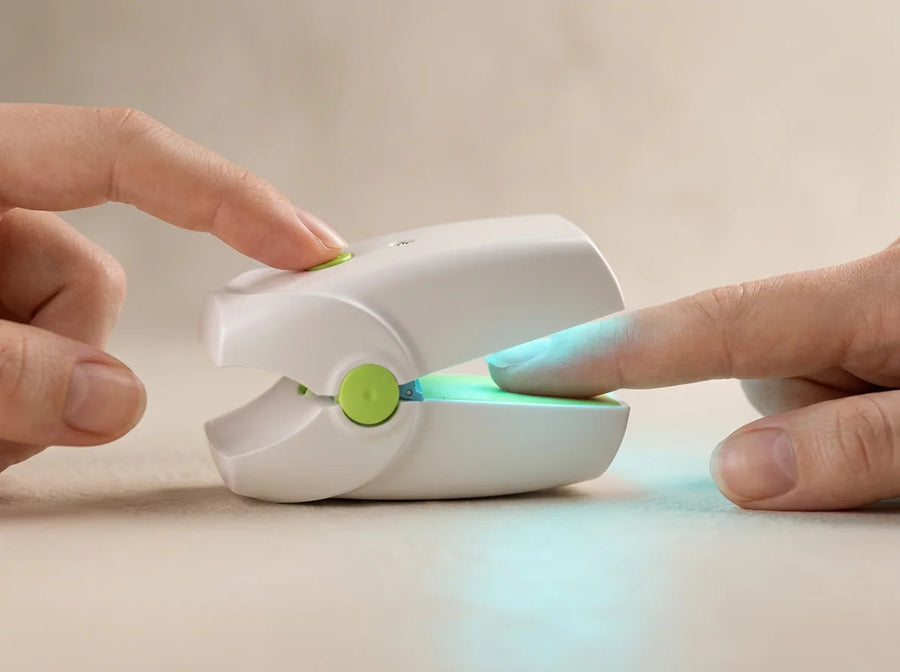 A finger pressing the green button on the device