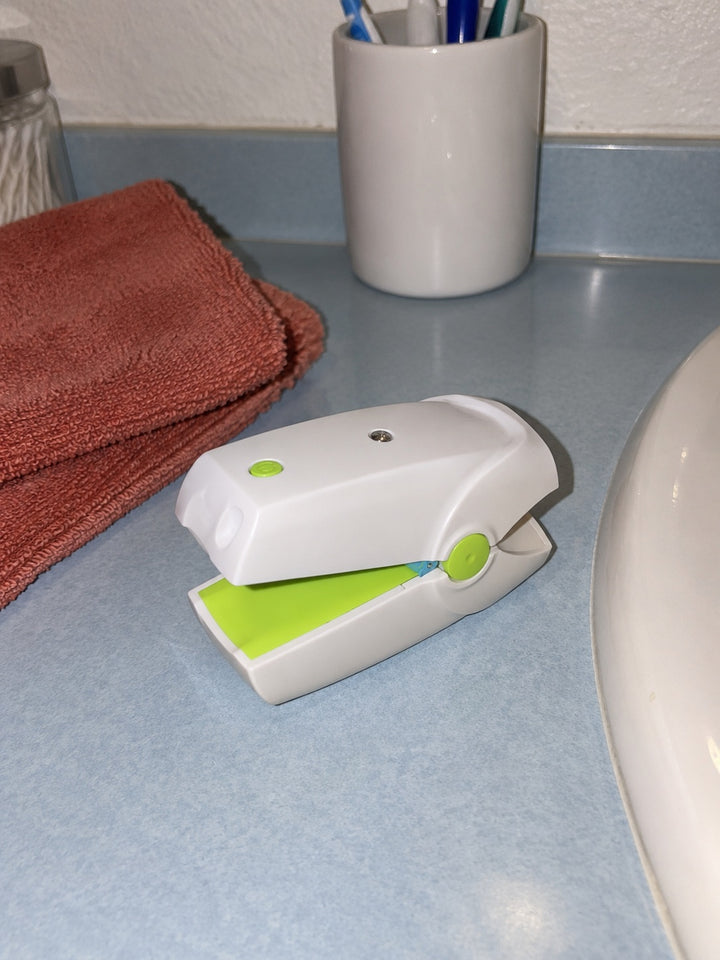 AI-created illustration of a NailNova device and charging accessories on a bathroom counter.